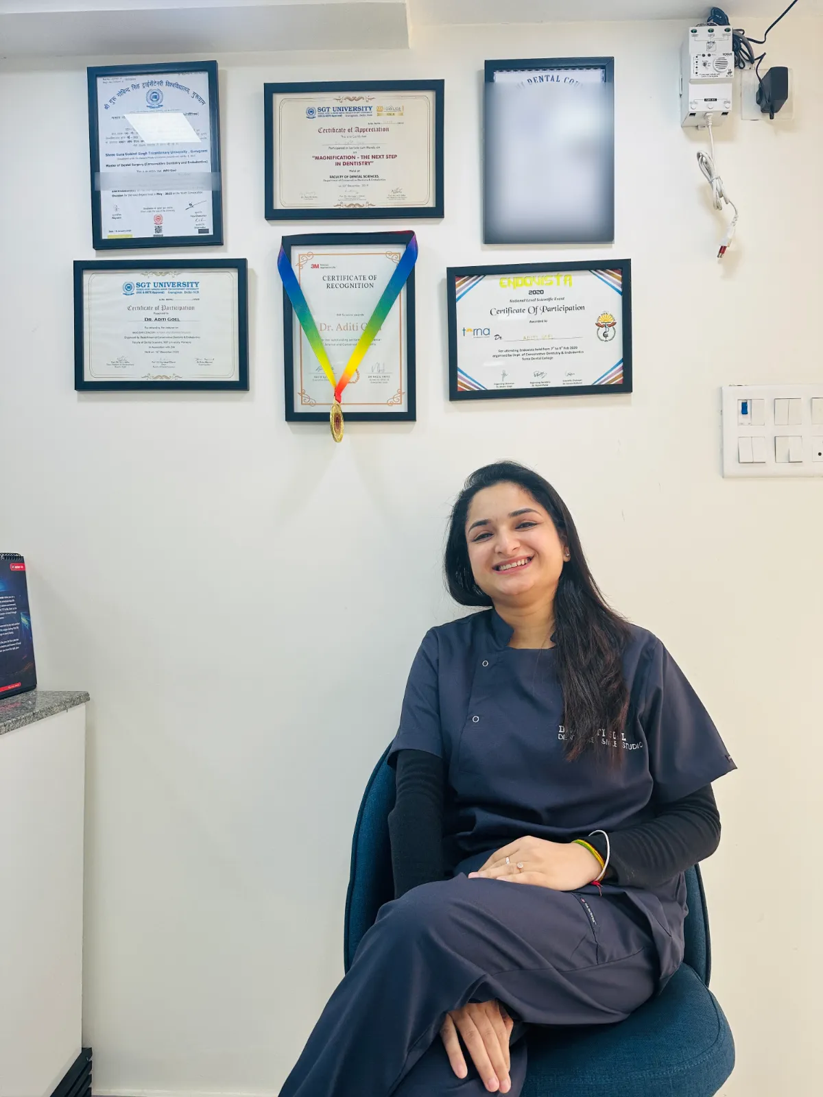 Dr. Aditi Goel with her MDS in Conservative Dentistry and Endodontics degree and dental certificates at Dentaire Smile Studio